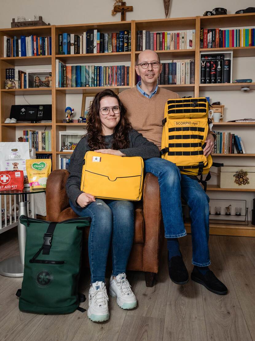 Dewi and her dad sitting on a chair with their emergency kit